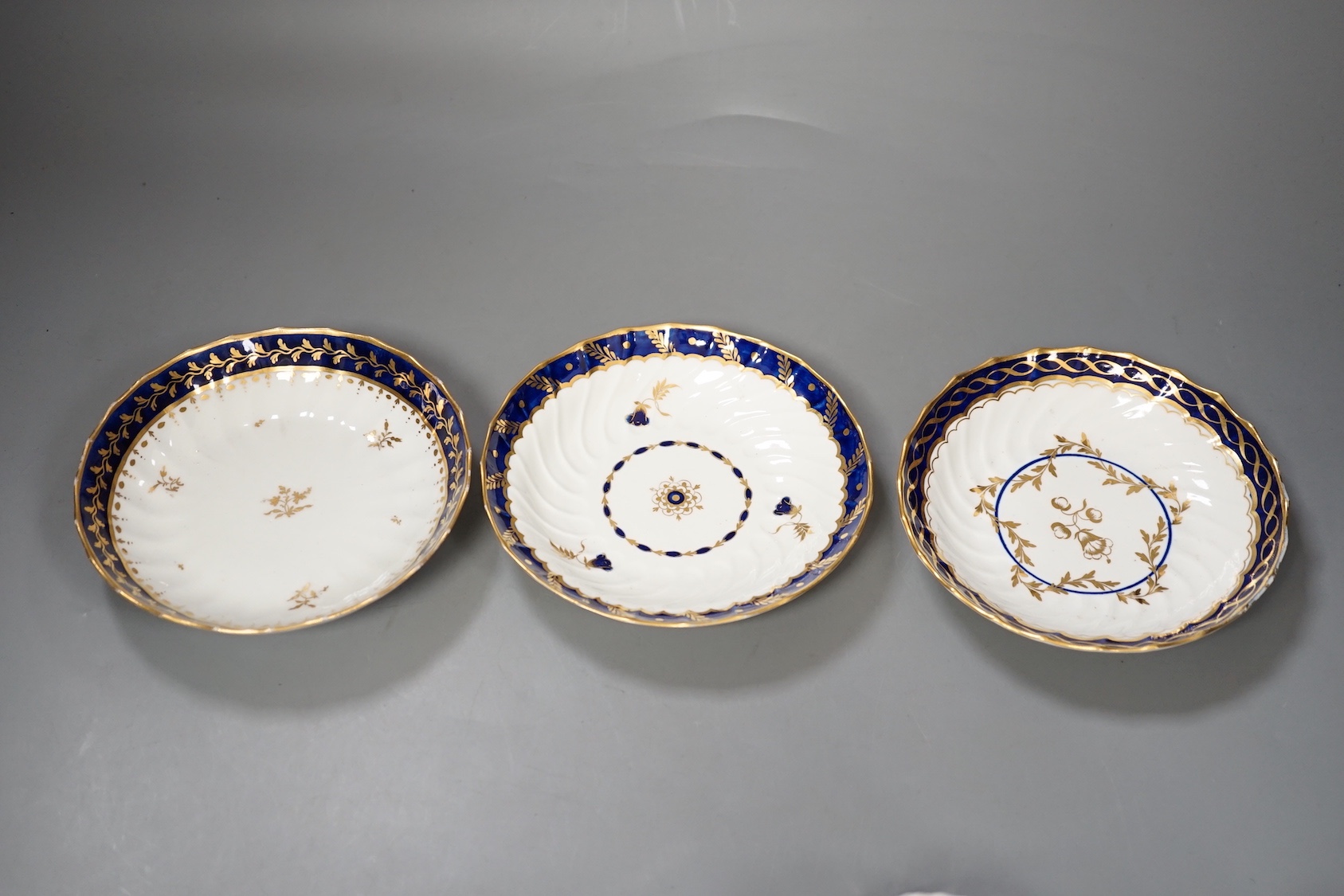 Three flight Worcester shankered teawares two coffee cup and saucers with blue borders and a teabowl and saucer similar c.1790